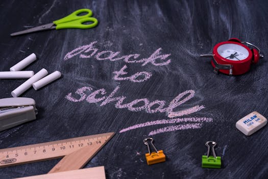 An arrangement of school supplies with 'back to school' written on a chalkboard.